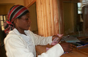 A local resident deposits money at  one of the licensed Umurenge saccos
