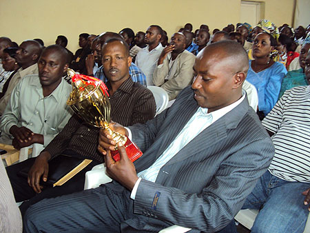 Nyamabuye executive secretary, Jean Batispte Mugunga, admires a trophy awarded to the sector. (Photo D.Sabiiti)