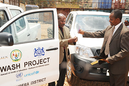 The  Mayor of Burera (l) receiving the keys of the new car fromUNSCO country chief.