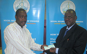Rwanda Cricket Association Secretary General Emmanuel Byiringiro (L) receiving a Frw2m cheque from CSRu2019s Acting Director Oswald Munyandekwe. (Courtsey photo)