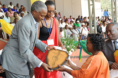 Dr. Charles Murigande awarding a trophy to, Sarah Ingabire, the Headmistress of FAWE girls yesterday (Photo; T. Kisambira)