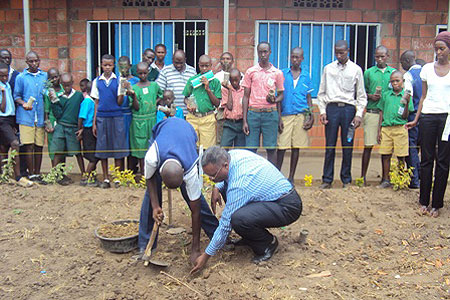 Bralirwa's corporate affairs head, Freddy Nyangezi helping a student plant a tree at the school compound. Photo D Ngabonziza