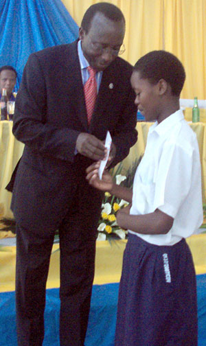 The Director General of the National Post office, Celestin Kayitare rewarding Christine Dusenge as best writer. (Photo / G. Mugoya)