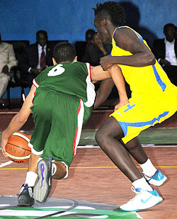 Algeria's Bourkaib Mohammad dribbles past Rwanda's point guard Brian Nkusi. (Photo T. Kisambira)