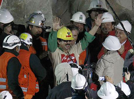 An elated rescued miner waves