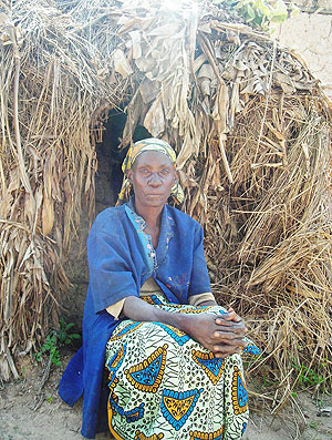 A woman sits infront of her grass thatched hut in Gisagara district, many such dwellings can be found in the Southern Province. (File Photo)