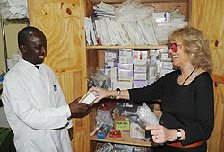 Dr. Patrick Bagambe receiving medical equipment from Barbara A Margolies yesterday (Photo; T. Kisambira)