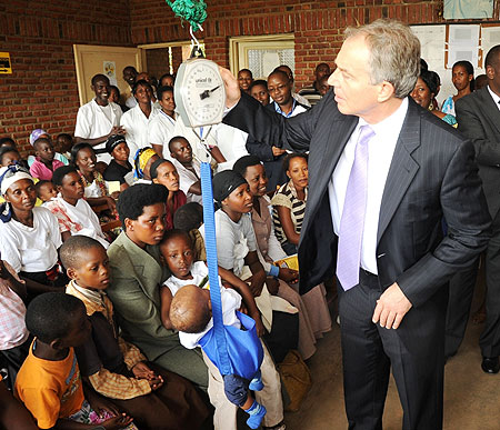 Tony Blair weighing baby Patience Mugabe at Kicukiro Health Centre yesterday (Photo; T. Kisambira)