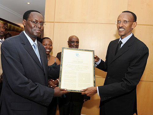 President Kagame receiving a certificate from Unity Club member, Faustin Nteziryayo - former Minister of Justice, on Saturday.  (Photo: Urugwiro Village)