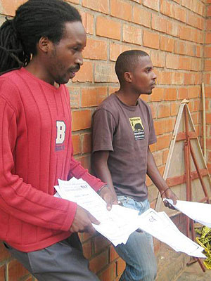 L-R Hitimana and Mutabazi displaying some of the counterfeit transcripts at CID headquarters yesterday (Photo; B. Asiimwe)