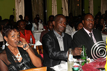 Pastor Alice Mignonne (L) takes a sip while Minister Protais Mitali (Extreme right) watches the action on stage