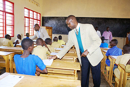 The State Minister for Primary and Secondary Education, distributing question papers to Pupils of Nemba 1 in Gakenke District yesterday (Photo; S. Mugisha)