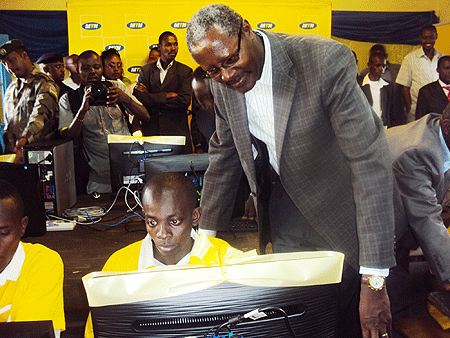 MTNu2019 Alphonse Byusa observes students as they try out their new computers.(Photo  S.Rwembeho)