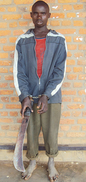 Muhayimana Noheli holds the blood stained panga which he used to kill his friend (photo S Nkurunziza)