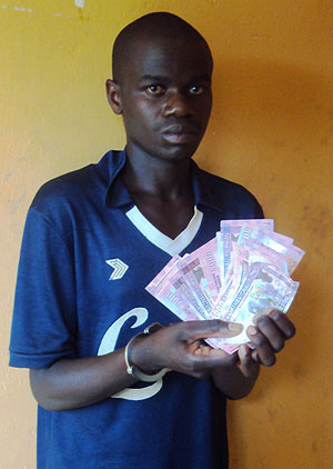 Bosco Muberankiko displays the fake Rwf5000 notes he was arrested with (Photo S Nkurunziza)