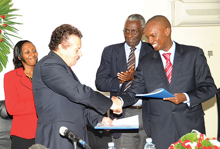 STG General Manager, Othman Ben Arfa, and Yves Muyange shake hands after the signing as Hon. Collette Ruhamya (L) Chrysologue Karangwa look on