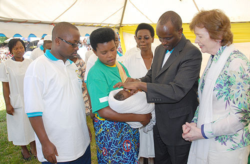 The Minister of Health, Dr. Richard Sezibera (2nd right) administers a Polio Vaccine to a Child as GAVI Chairperson Mary Robinson (right) looks on. (Photo; J. Mbanda) 