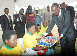 Dr. Richard Sezibera gives a Mosquito net to a Mother in Gashora at the launch of the Immunisation Program recently. (File photo)