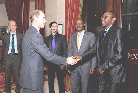 Prince Edward, the Duke of Edinburgh greets Pierre Kayitana while Ernest Rwamucyo, Rwandan Ambassador to UK, looks on.