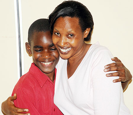 Jesse Mugisha who emerged best in the Primary Leaving Examinations with his aunt Annette Mutangwa (Photo T.Kisambira)
