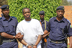 Jean Marie Vianney Mudahinyuka is led to detention by police officers following his deportation yesterday (Courtsey Photo)