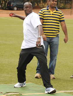 Former sports Minister Joseph Habineza tries out a game of cricket. (File photo)