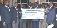 Some of the members of the Southern Province Business  Community join Prime Minister Bernard Makuza (C) for a photo with the cheque ( Photo G. Mugoya)