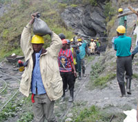 Miners carry wolfram from a mining site. (Photo B Mukombozi)