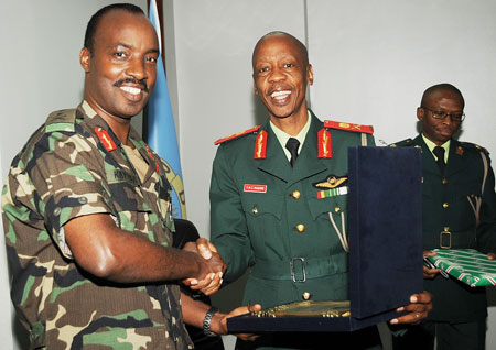 Chief of Defence Staff, Lt.Gen Charles Kayonga (L) ,exchanges gifts with his Botswana counterpart, Lt Gen.Tebogo Masire yesterday . (Photo J Mbanda)
