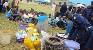 Residents watch some of the impounded local gin. (Photo: J.P Bucyensenge)