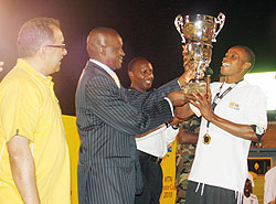 Former Sports Minister Joseph Habineza hands last year's MTN Peace Cup title to APR skipper Patrick Mafisango at Amahoro stadium. (File photo)