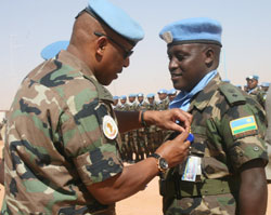 Gen. Nyamvumba pinning a medal on one of the Rwandan officers in Darfur (Courtesy photo).