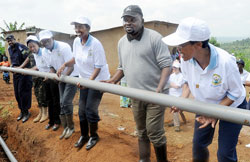 REMA's Rose Mukankomeje (R), City Vice Mayor Alphonse Nizeyimana,State Minister for water and Energy, Colletha Ruhamya, and other leaders lay water pipes in Kanombe Sector (Photo J Mbanda).