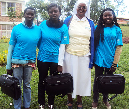 Best S.6 students of Zaza College with new laptops pose for a photo with their Headmistress Gorethe Umugwaneza. (Photo S. Rwembeho)