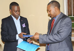6-5 Outgoing Chairman of Rwanda NGO Forum on HIV- AIDS Aimable Mwananawe (R) hands over to his successor Dr. Prince Bosco Kanani. (Photo J Mbanda)