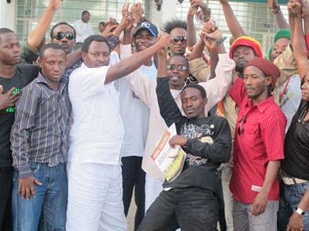 Runyurana (centre in white outfit) poses with musicians in a group photo.