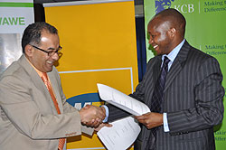 MTNu2019s Chief Executive Officer, Khaled Mikkawi and Maurice K. Toroitich, the Managing Director of KCB Rwanda exchange documents after signing the deal