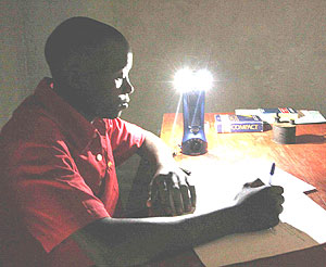 A Rwandan student, compares studying with a kerosene lamp made from a tomato can to studying with a Lifelight.(Net photo)