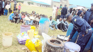 Residents watch some of the impounded local gin. (Photo: J.P Bucyensenge)