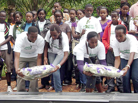 Student leaders and teacher (L) lay wreaths on the Mass graves