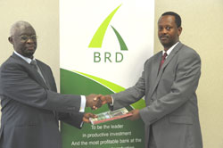 Former Managing Director of BHR Gervais Ntanganda exchanges documents with Jack Kayonga, the Managing Director of BRD (Photo T.Kisambira