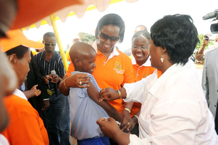 First Lady Jeannette Kagame comforts a girl after getting her vaccination from Dr Binagwaho. Minister Jeanne du2019Arc Mujawamariya  looks on (Photo: J. Mbanda).
