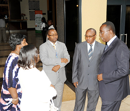 Prime Minister Bernard Makuza (R) speaks to the Permanent Secretary at the Ministry of Health Dr. Binagwaho after opening the international conference on cervical cancer. Looking on are Ministers Musoni and Nsanzabaganwa (L) and Dr. Fidel Ngabo (Photo J M