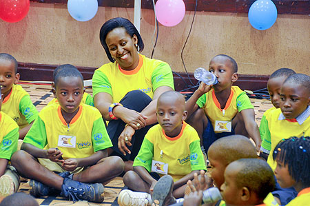 First Lady  Jeannette Kagame shares a light moment with children at Serena Hotel during a function to mark the Reading Day (Photo T.Kisambira).