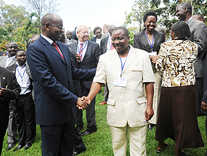 Local Government Minister James Musoni (L) interacts with participants of the Workshop. (Photo J Mbanda)