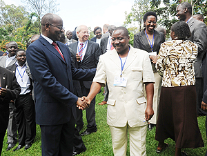 Local Government Minister James Musoni (L) interacts with participants of the Workshop. (Photo J Mbanda)
