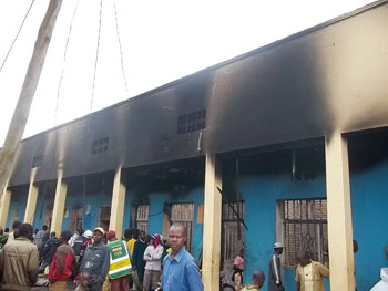 Curious residents gather at the scene of the razed building (Photo B Mukombozi)