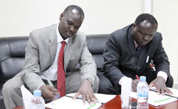 Chirstophe Bazivamo (R) and Minister Stanislas Kamanzi signing documents during the handover yesterday (Photo T Kisambira)