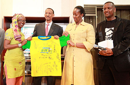 (L-R) Josiane Uwineza a.k.a Miss JoJo presents President Paul Kagame and First Lady Jeannette Kagame with a gift of the Amavubi T-shirt  while Intore Masamba looks on  (Photo T.Kisambira).