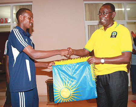 Prime Minister Bernard Makuza hands over the national flag to the U-17 Amavubi captain Emery Bayisenge (Photo T Kisambira)